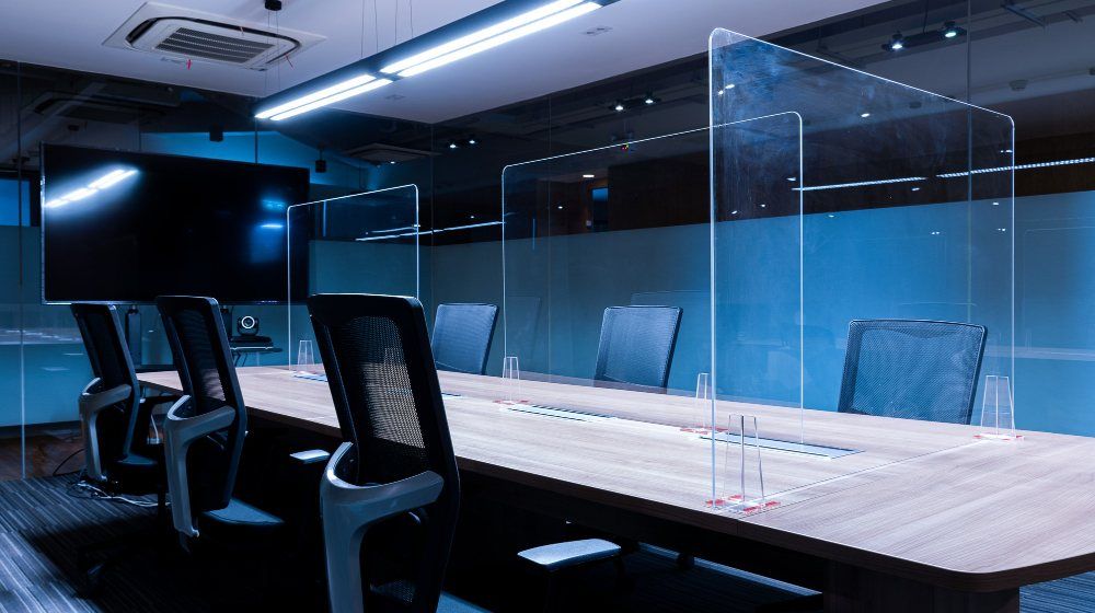 transparente sépare le centre de la table de conférence pour empêcher Covid-19